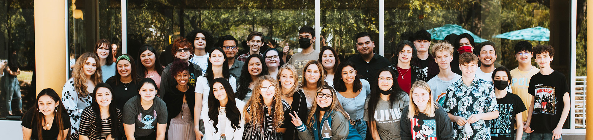 Group of students smiling outside school building