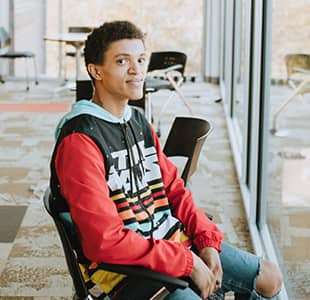 Male Student Sitting in chair smiling